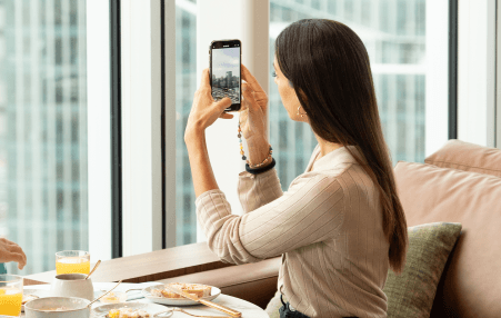 woman taking photo during breakfast